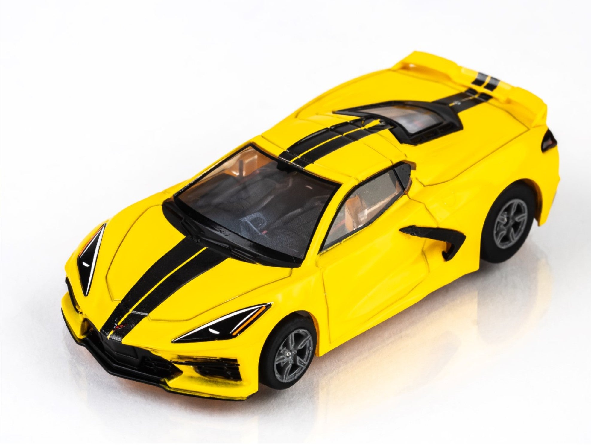 Front view of AFX Corvette C8 slot car in Accelerate Yellow with black trim and hood stripes