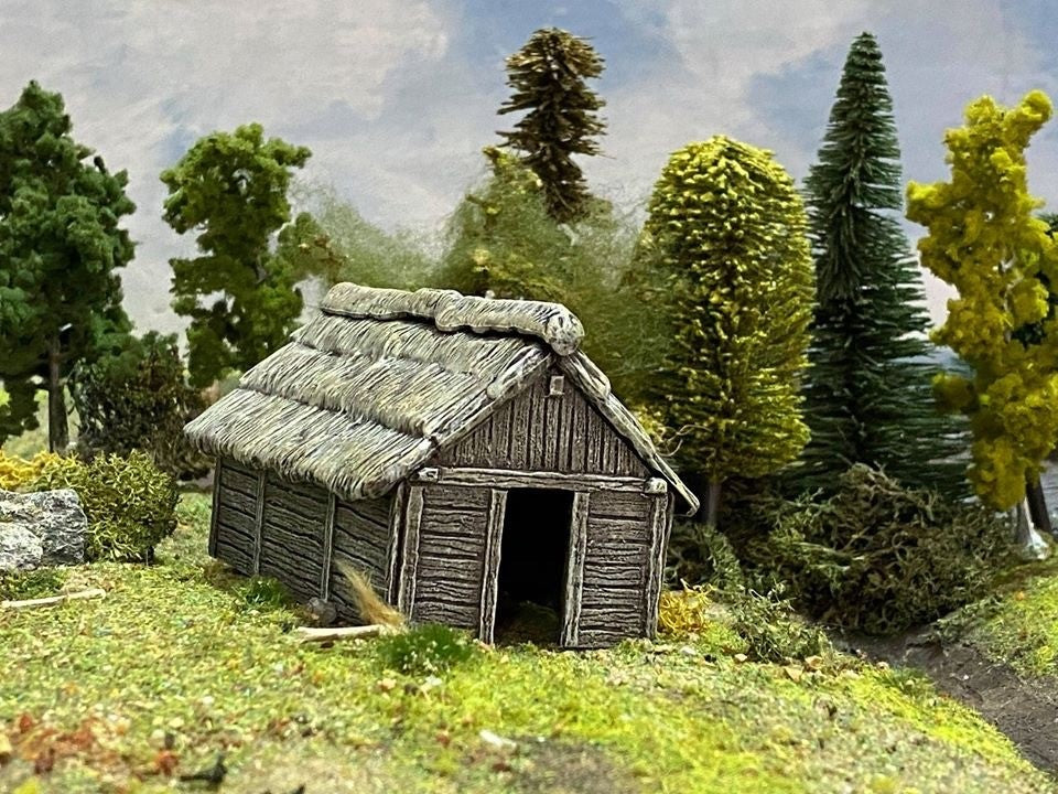 Renedra Fully assembled and painted 28mm scale Timber Outbuilding shown in a rural wargaming diorama with realistic foliage.