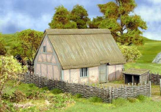 Fully assembled and painted 28mm scale Wattle Fencing enclosing a thatched medieval peasant house in a rural wargaming diorama