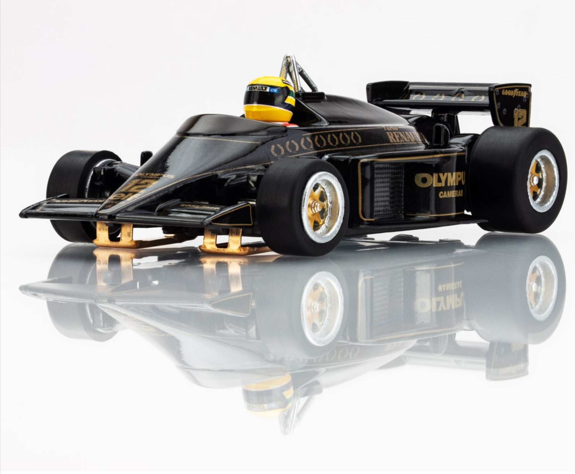 Front-left angle of AFX 1985 Lotus 97T HO scale slot car with gold Olympus sponsorship and high-gloss finish.