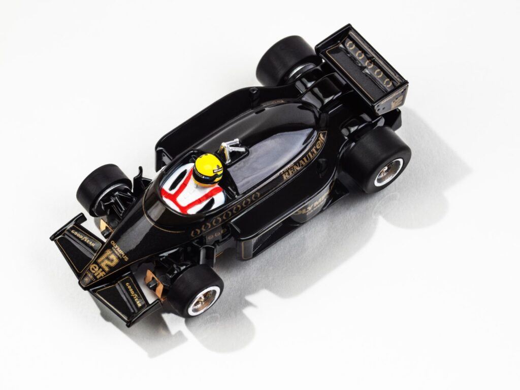 Top-down view of the black and gold AFX Lotus 97T slot car showing #12 and driver Ayrton Senna.