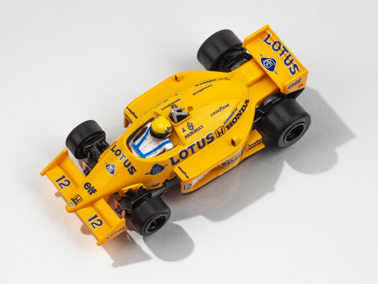 Top-down view of the AFX Lotus 99T yellow and blue F1 slot car showing #12 and Senna branding.