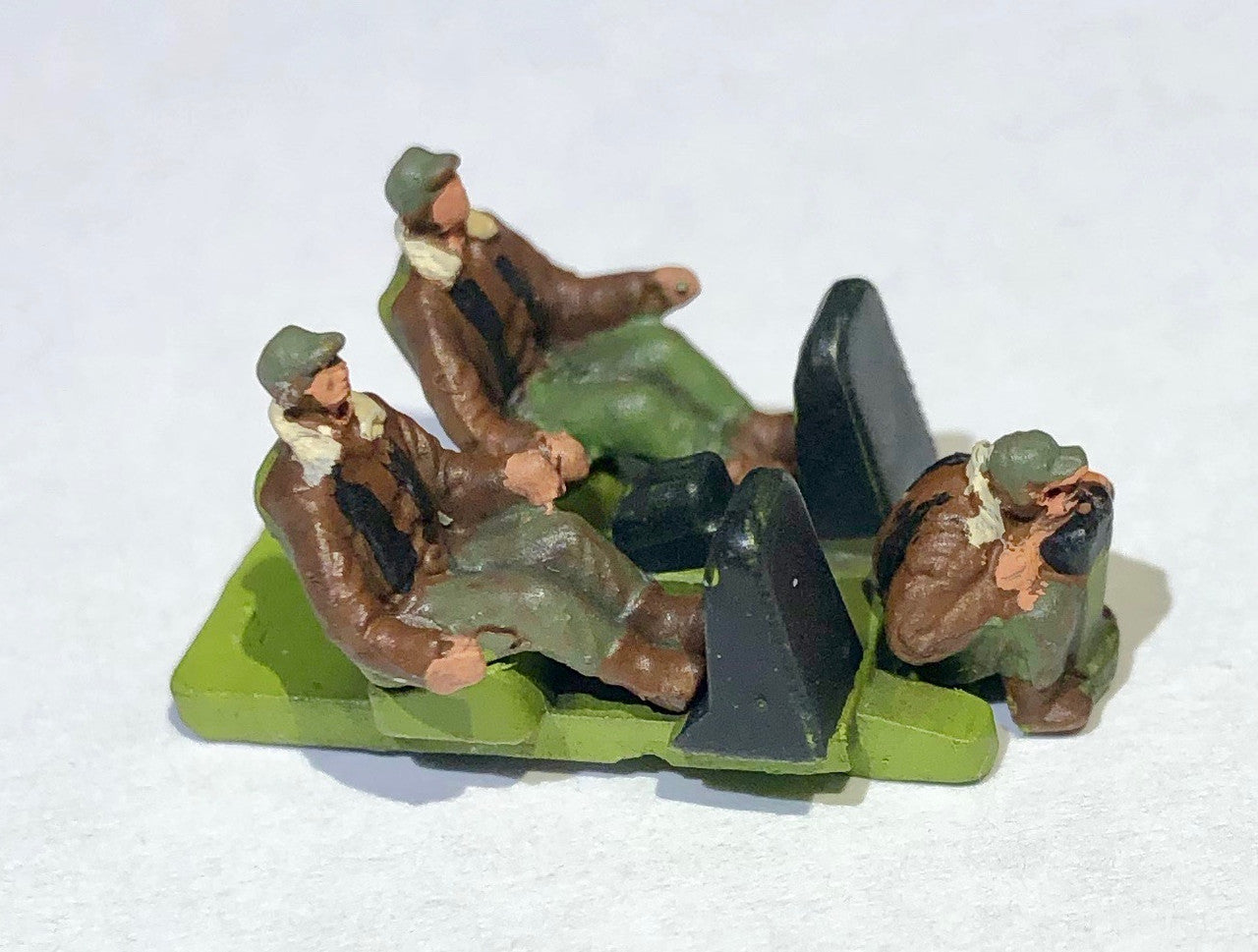 Close-up view of the three included  plastic pilot and cockpit crew figures on their flight deck base