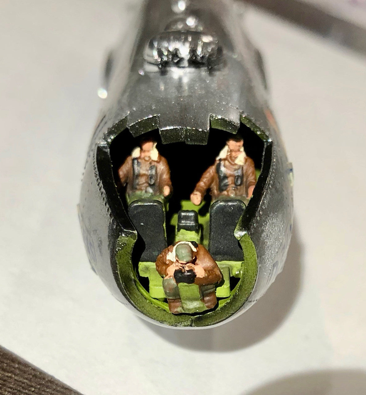 Front view looking inside the nose showing the three crew figures positioned in the cockpit