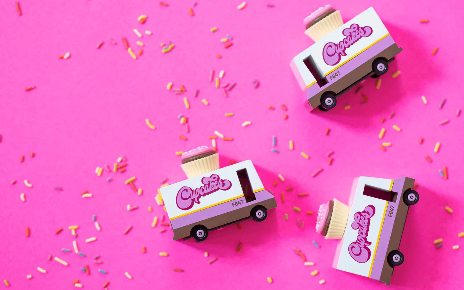 Candylab Toys Cupcake Vans – Multiple Wooden Vehicles on Pink Background with Sprinkles