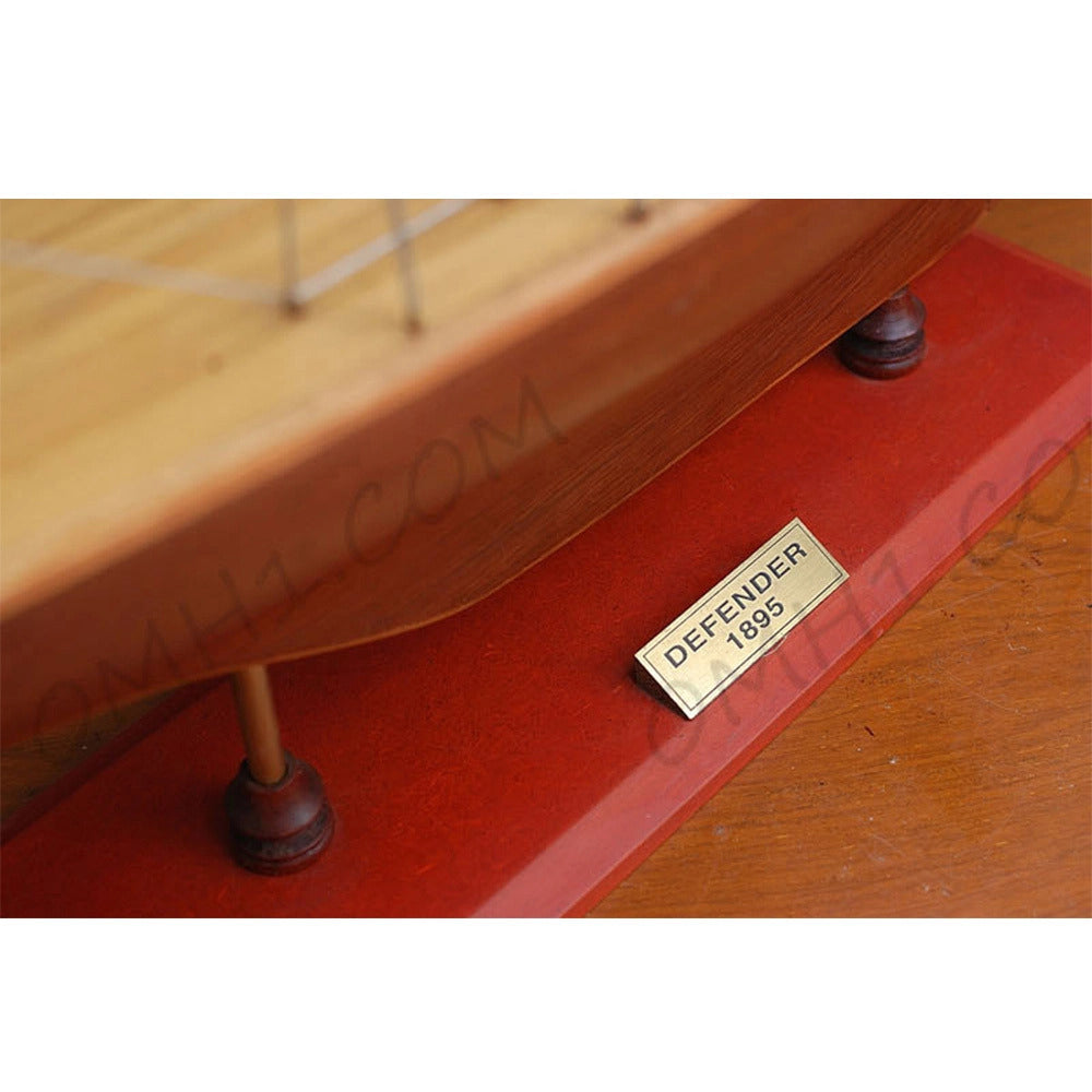Captain Heritage Defender Sailboat Schooner Yacht, featuring the brass Defender 1895 nameplate mounted on the display base.