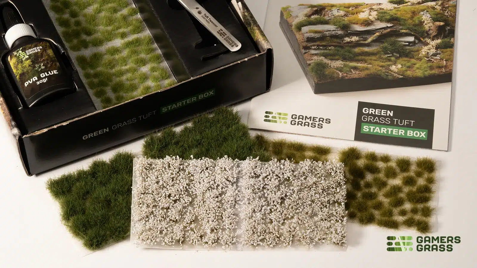 Detailed view of Gamers Grass starter box contents: 4 tuft sheets, White Flowers, and precision tweezers.