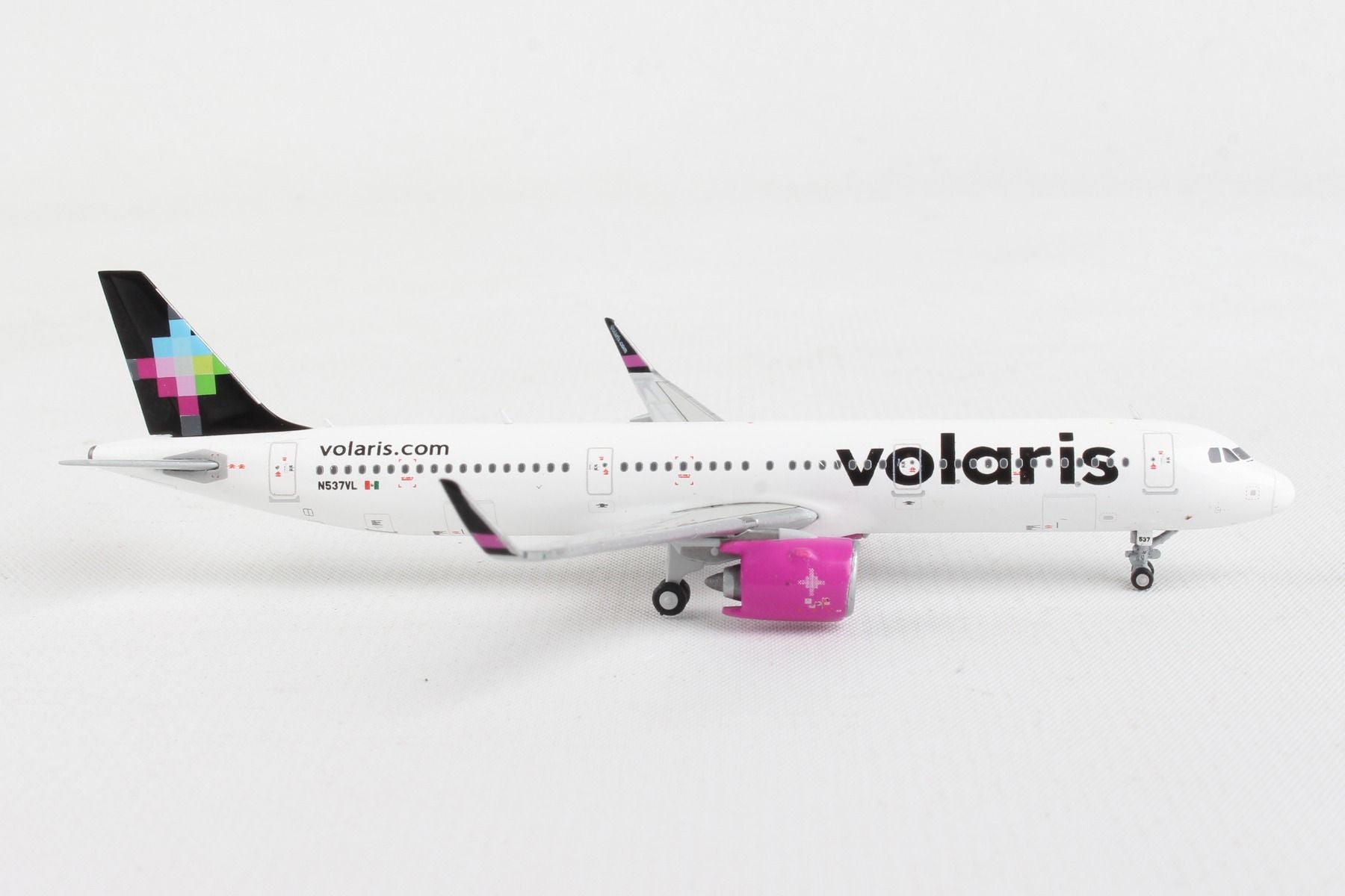 Right side profile of GeminiJets 1 by 400 scale Volaris Airbus A321neo diecast model showing pink engine accents 