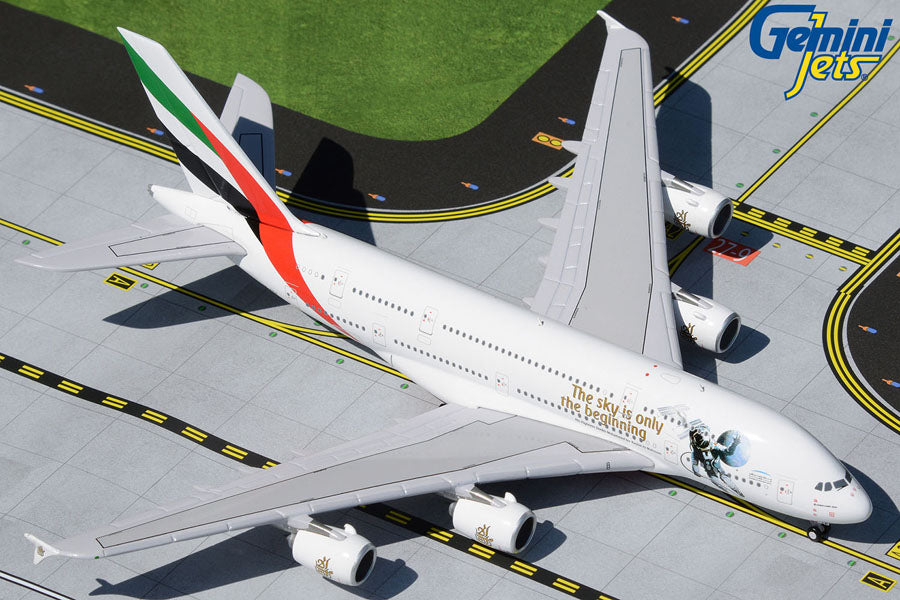 High angle overhead view of GeminiJets 1 by 400 scale Emirates Airbus A380 UAE in Space diecast model airplane on a runway mat showing astronaut graphic