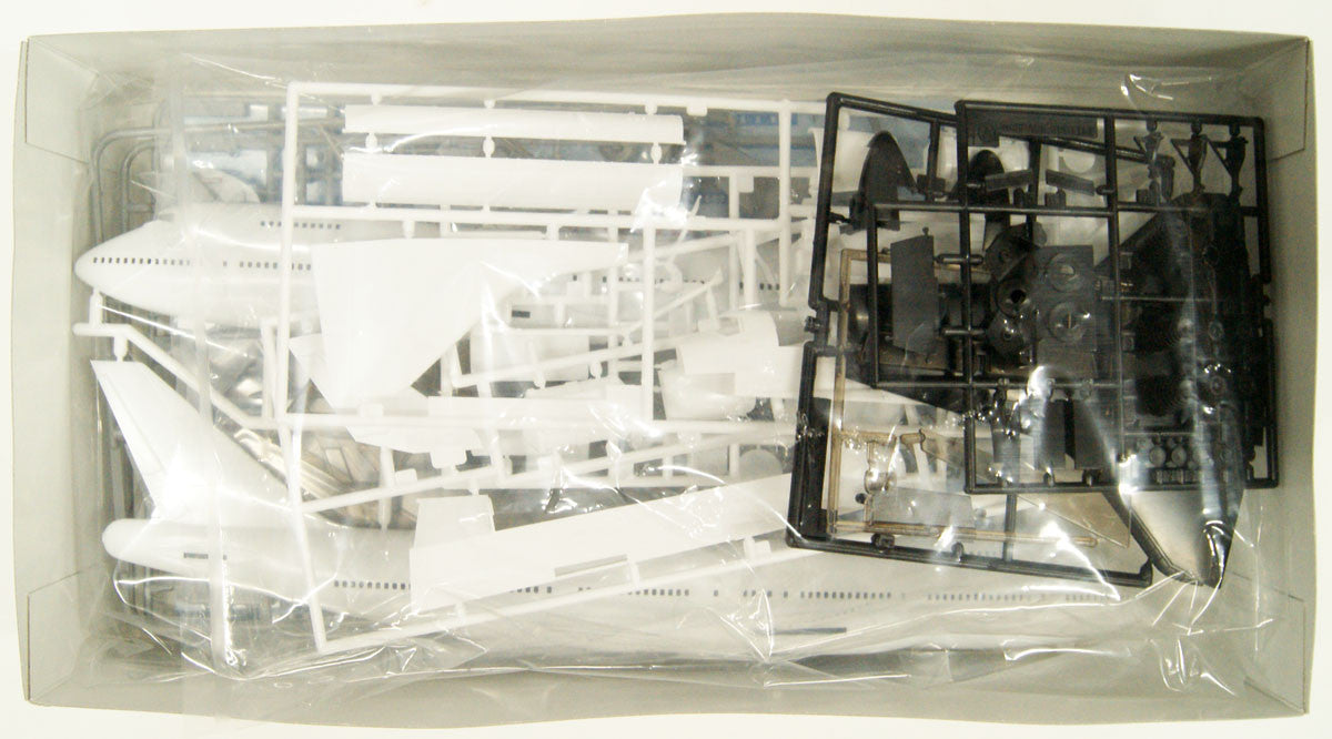 Unboxed view of the Hasegawa 10844 model kit contents, showing the white and black molded plastic part sprues securely sealed in factory packaging.