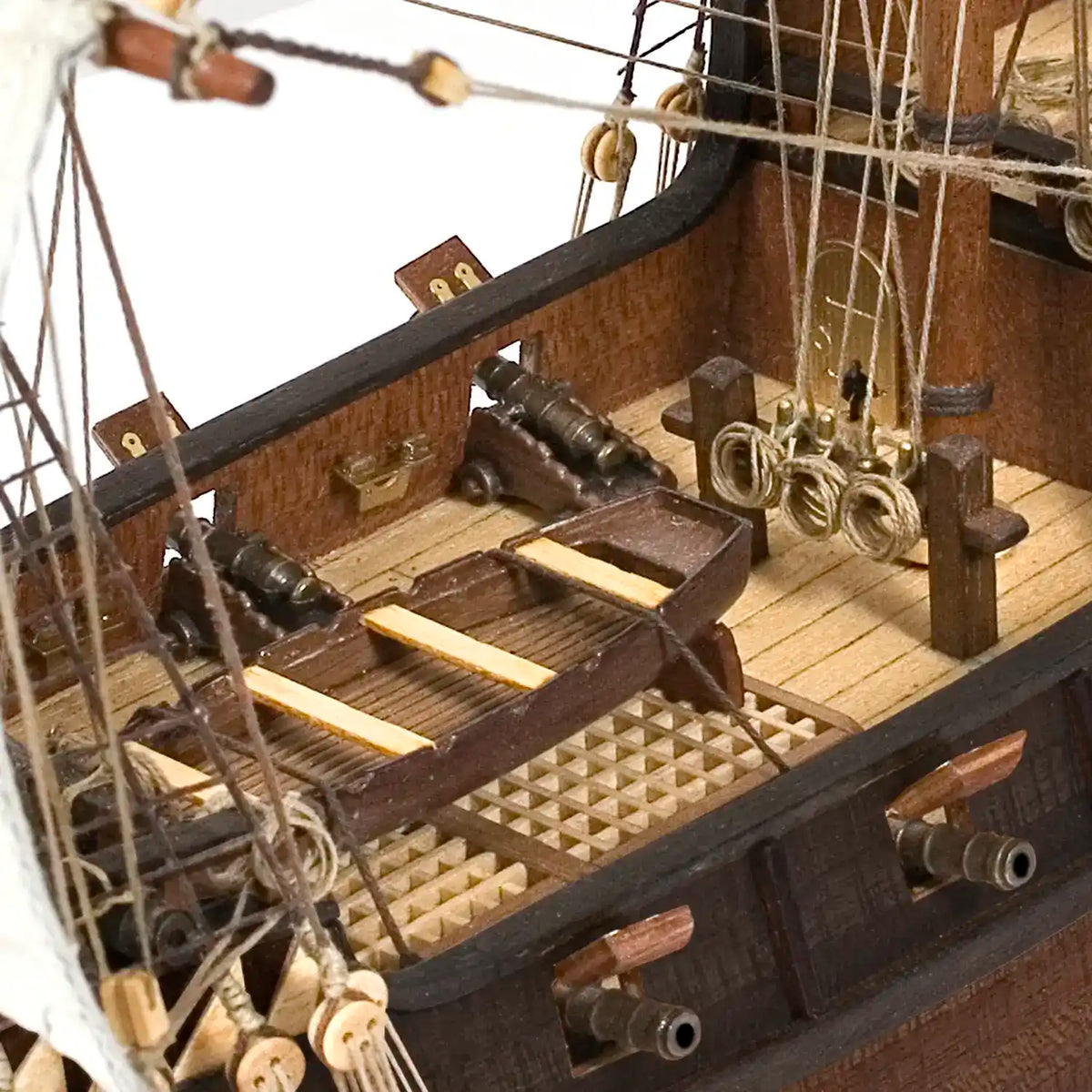 Close up of cast zamak cannons on wooden carriages and coiled rigging rope along the Occre Buccaneer gun deck