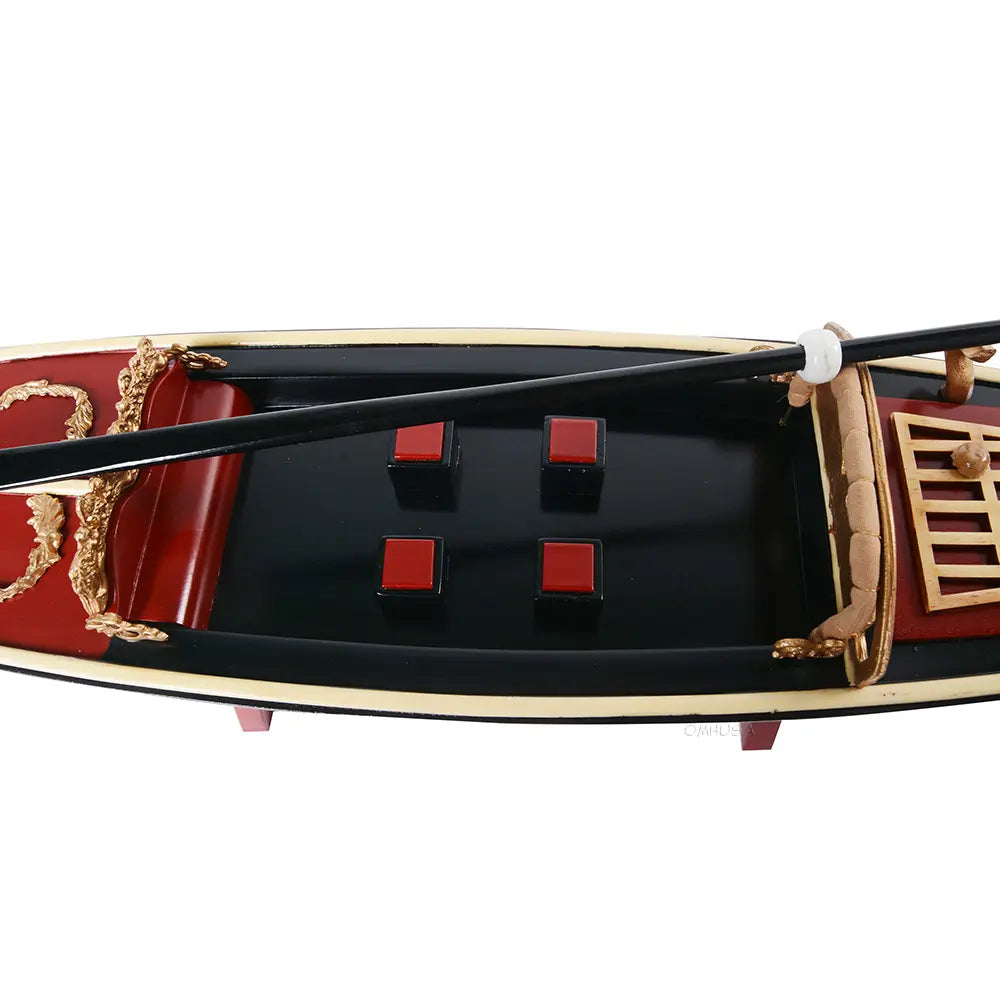 Close-up of red-painted seating area and gold-plated bow ornament on Gondola model