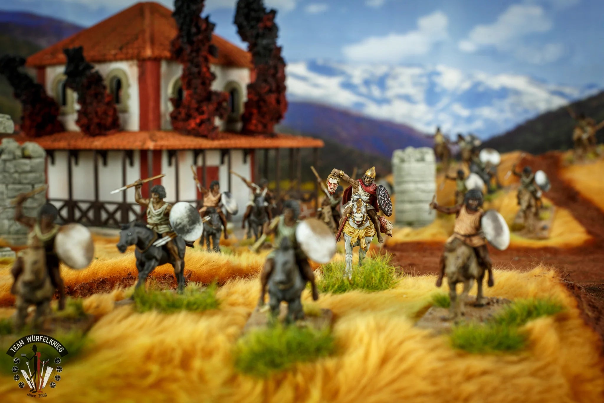 Painted Victrix 28mm Numidian cavalry models charging past a burning Roman villa diorama