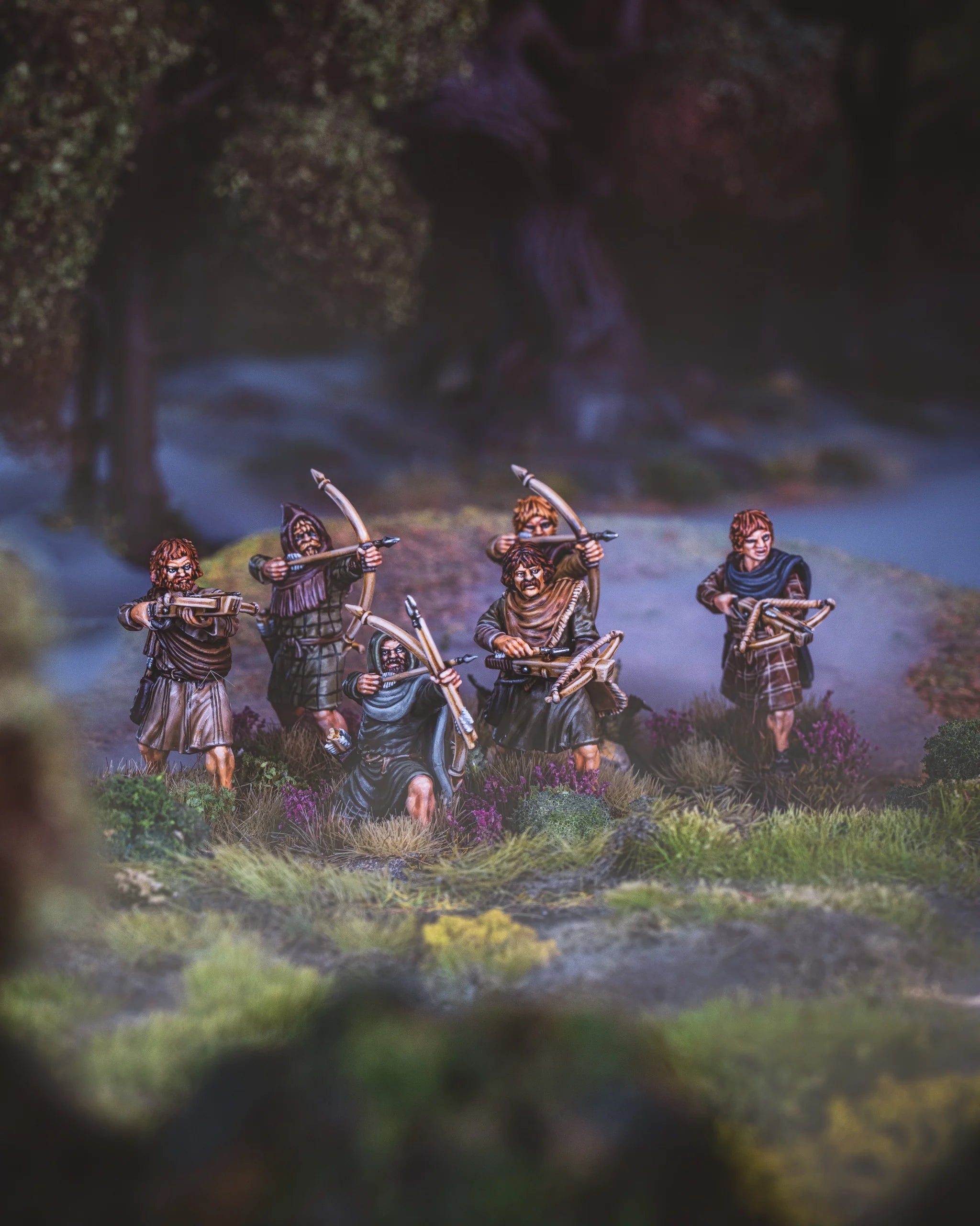 Group of painted Victrix 28mm Pictish archers and crossbowmen advancing through a foggy forest diorama