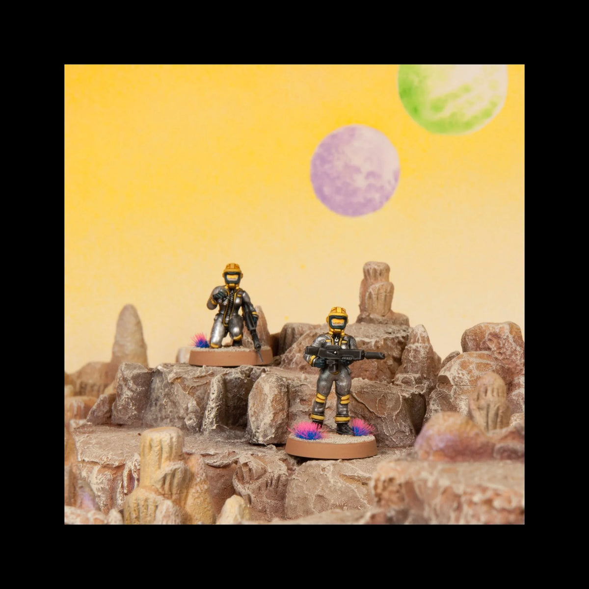 Painted 28mm female sci-fi figures wearing hazmat space helmets exploring rocky alien crags