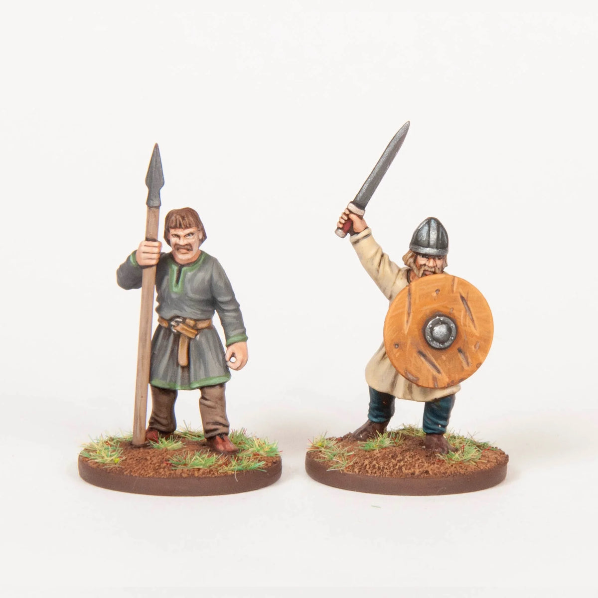 Two painted Dark Ages figures representing an unarmored spearman and a swordsman with a round shield 