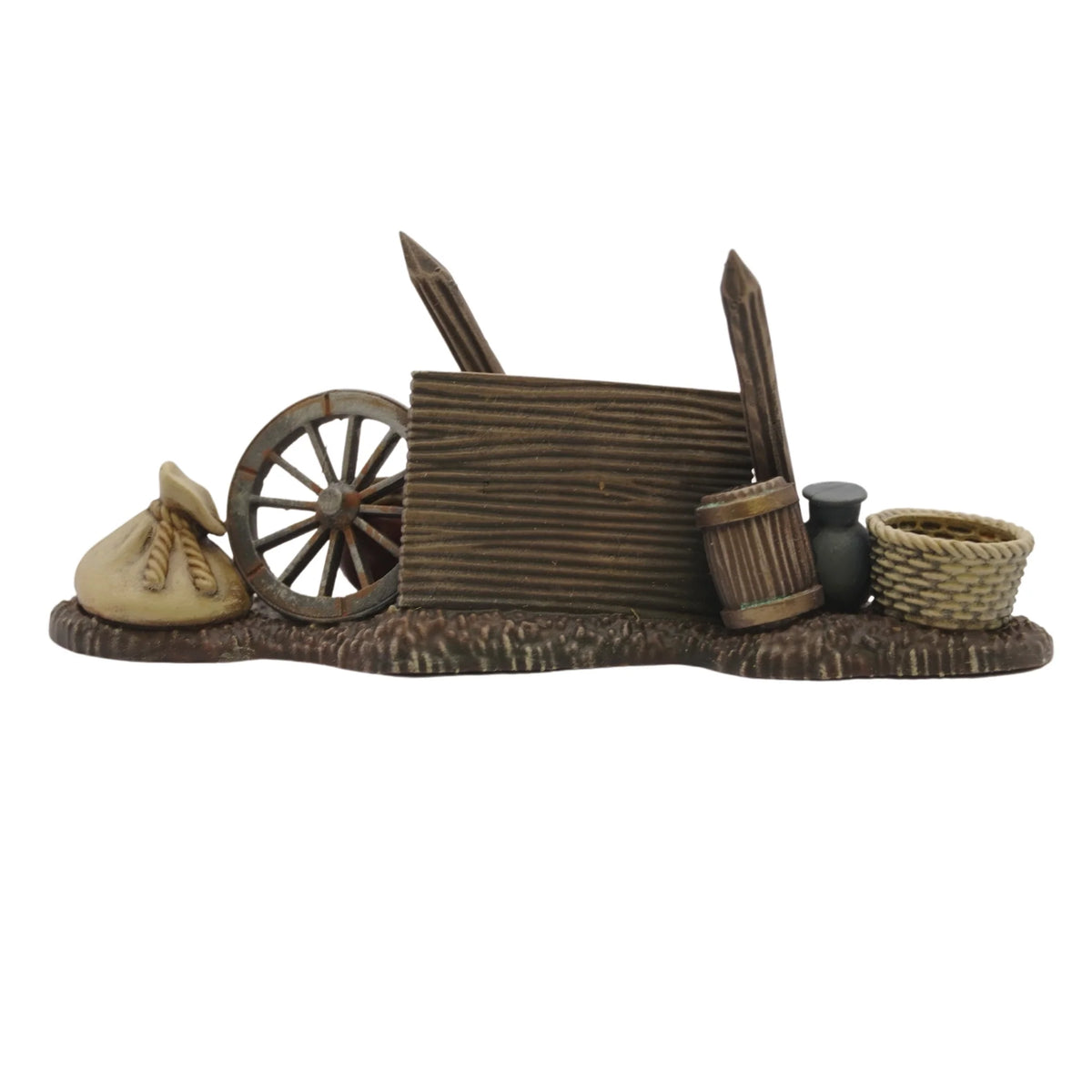 Painted defensive barricade built with an overturned cart wheel, wooden wall, barrel, and woven basket 