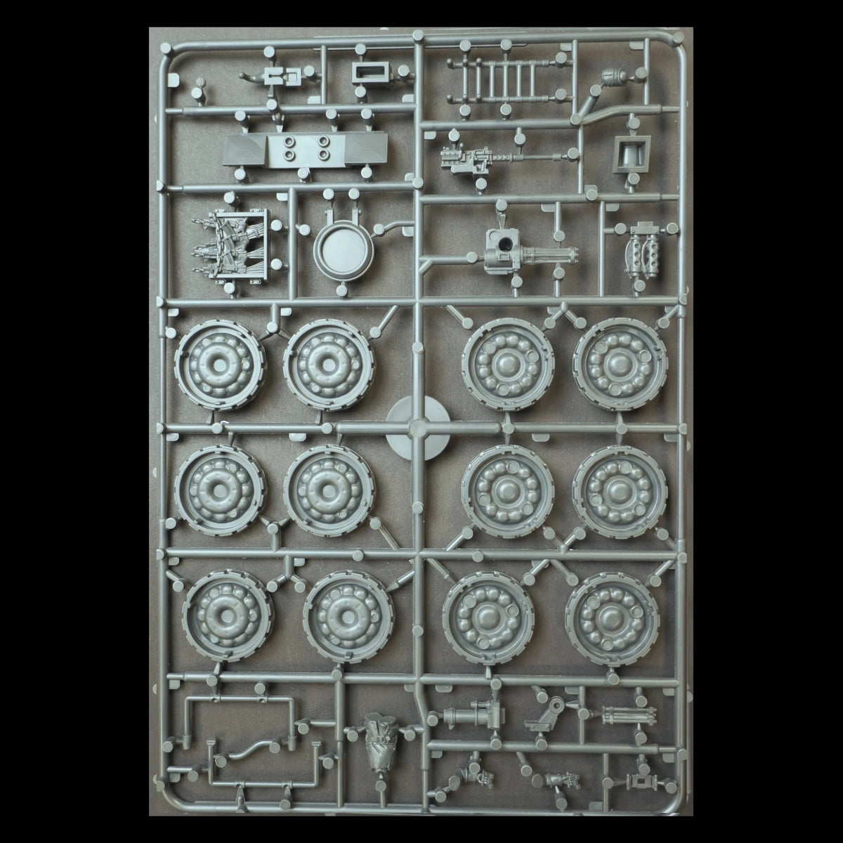 Back view of sprue frame C displaying wheel hubs, weapon assemblies, and crew bits for the 28mm sci-fi vehicle kit