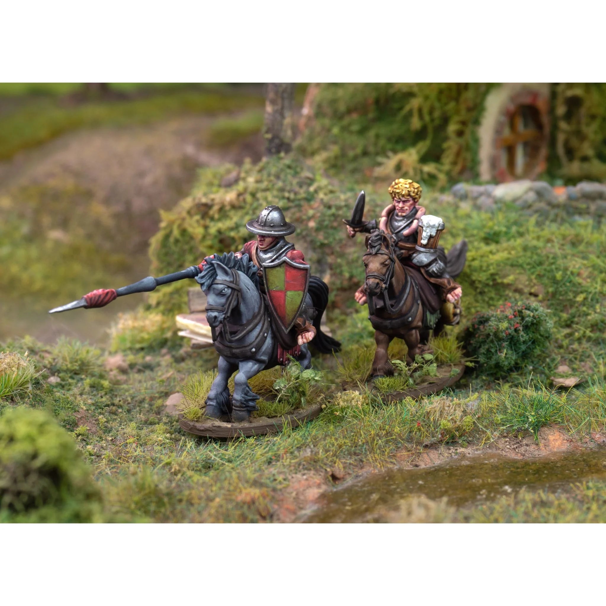 Two painted halfling cavalry models scouting along a riverbank near a grassy knoll
