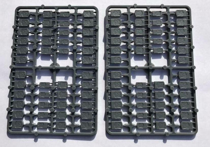 Two identical gray hard plastic sprue frames from the Renedra American Gravestones A scenery kit showing dozens of shield-shaped headstones