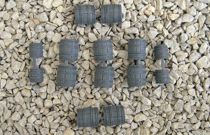 Ten fully assembled gray hard plastic Renedra miniature barrels showing the mixed sizes on a gravel surface.
