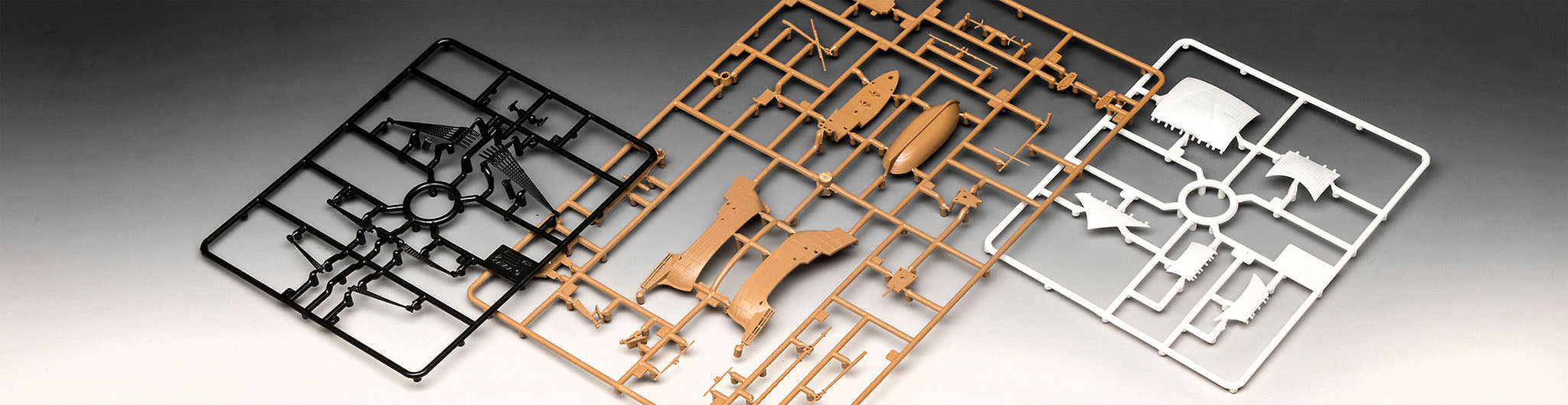 Multi-colored injection-molded sprues in black, brown, and white plastic for Revell 05660.
