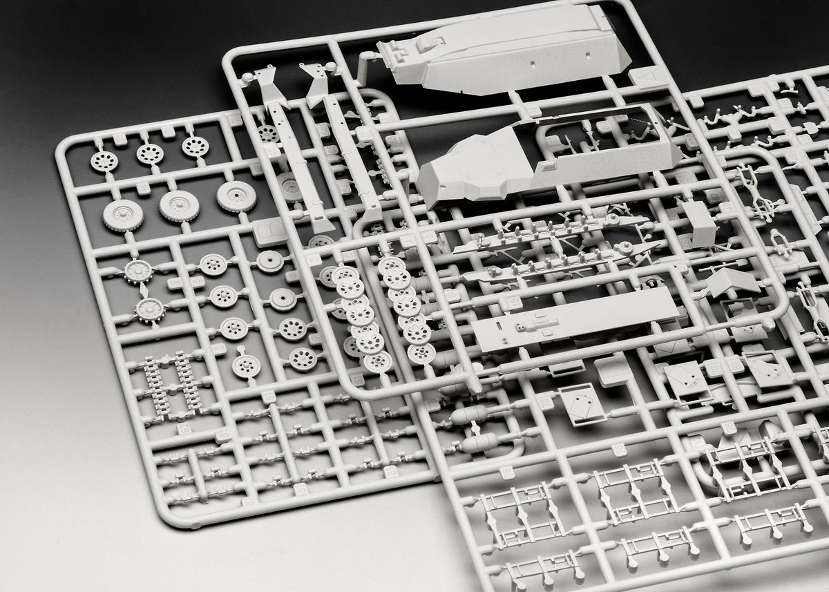 Injection-molded plastic sprues showing hull parts, running gear, and rocket launcher frames.