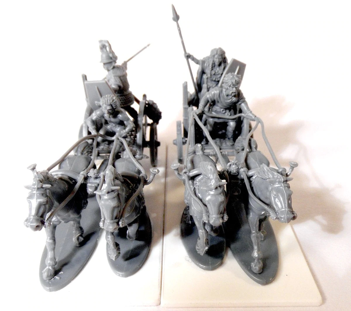 Front angle of unpainted gray plastic Victrix 28mm Celtic chariots showing charging horse teams