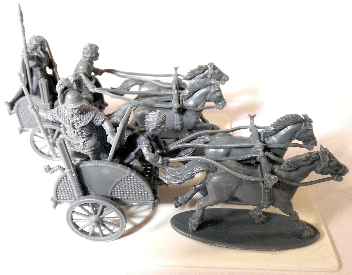 Side view of unpainted gray plastic Victrix 28mm Celtic chariots with warrior and driver figures
